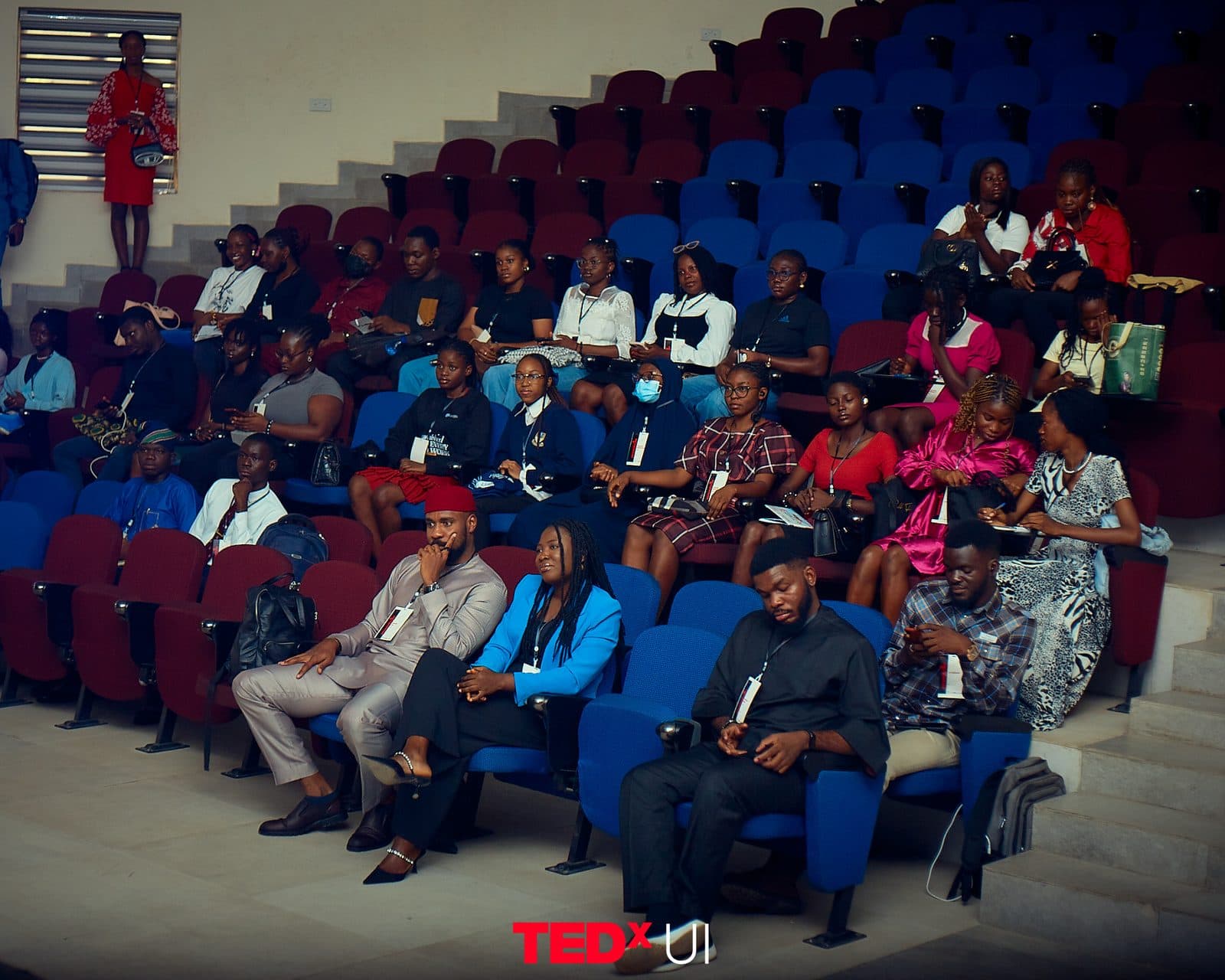 Attendees seated in the raked auditorium, listening to a talk.