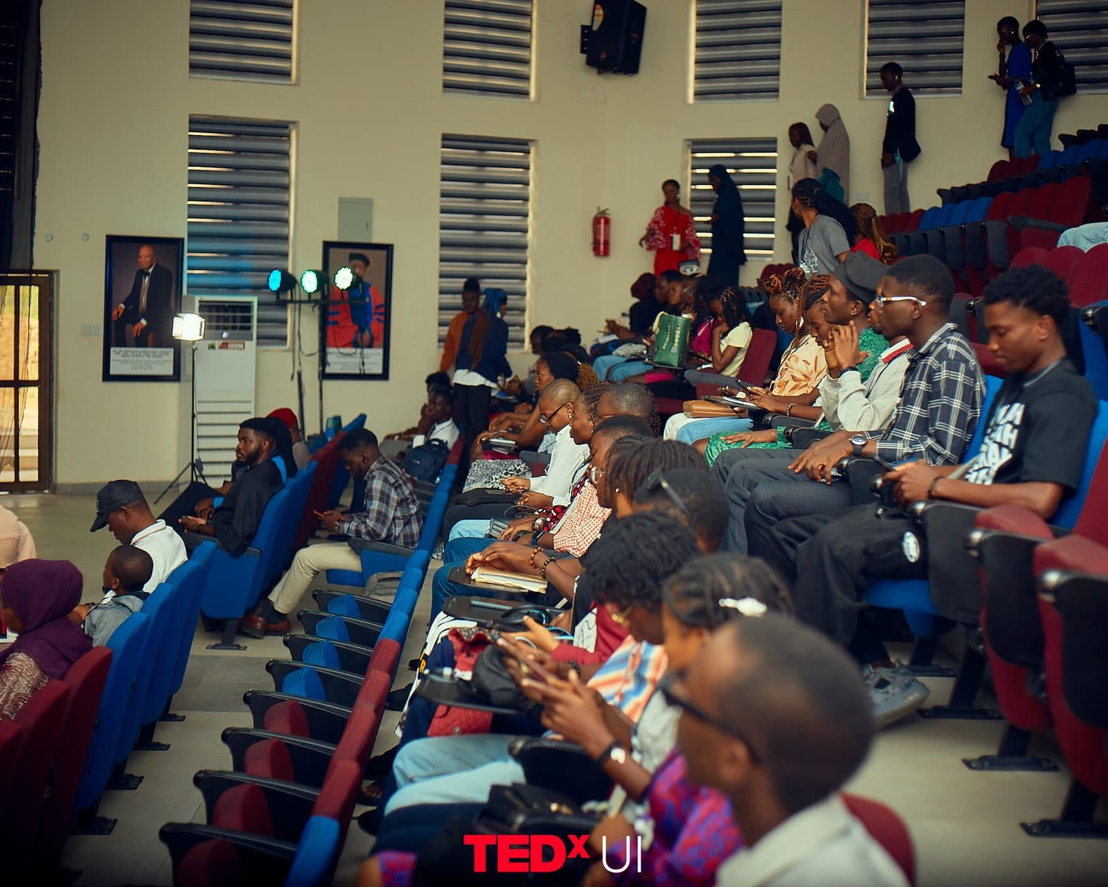 A wide view along a full row of the audience during a session.